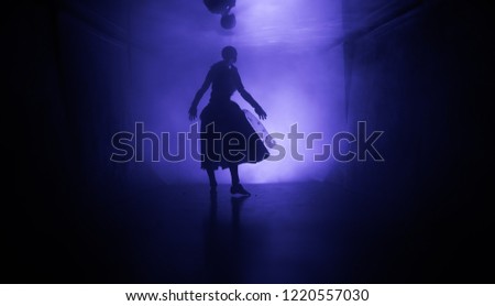 Creepy silhouette in the dark abandoned building. Horror about maniac concept or Dark corridor with cabinet doors and lights with silhouette of spooky horror doll standing with different poses.