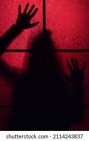 Creepy Silhouette Of A Man Behind A Closed Door In Red Light