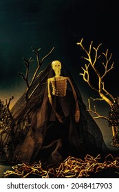 Creepy Skeleton Bride With Black Wedding Gown And Veil Standing At The Graveyard On The Dark Night. Halloween Concept. 