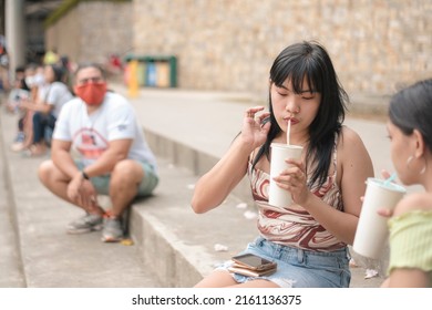 A Creepy Stalker Stares At Two Young Asian Women Nearby At A Public Area. Uncomfortable Situation Bordering On Sexual Harassment.