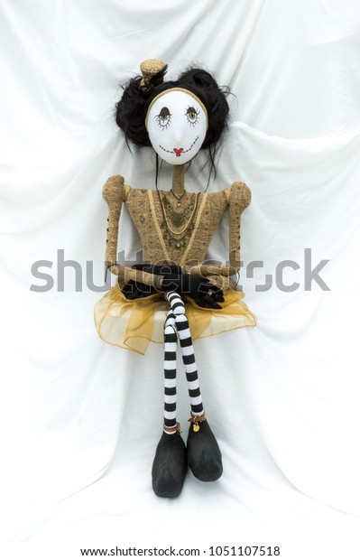 Creepy steampunk rag doll sitting facing\
forward. Legs crossed. Lifesize doll on a grungy white background.\
Part of a series of different poses.\
Vertical.