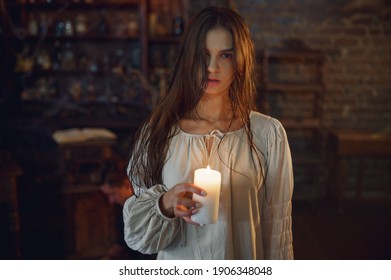 Creepy woman holds candle, demons casting out - Shutterstock ID 1906348048