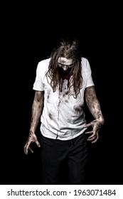 Creepy Zombie Man With Bloody Face And Shirt Standing Isolated Over Black Background. Scary Man With Long Hair In Dirty White Clothes. 
