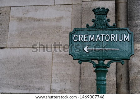 Crematorium. Inscription on a metal panel. Cemetery path.