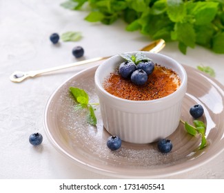 Creme brulee dessert with blueberries and mint leaves. Close up. - Powered by Shutterstock