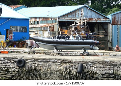 Cremyll Cornwall England. Ship Repair Yard With Rubber Inflatable Special Boat Service Or SBS Craft On Quayside On Trailer. Seating And Blue Lamps On Vessel. 