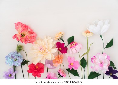 Crepe Paper Flowers On White Wooden Background