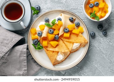 Crepes (Blini ruso) sobre fondo gris,. Crepes finas caseras frescas para el desayuno o el postre. Vista superior