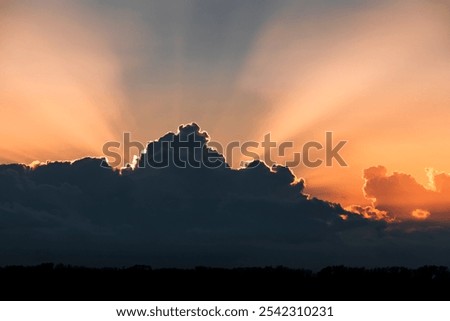 crepuscular rays behind dark clouds at sunset