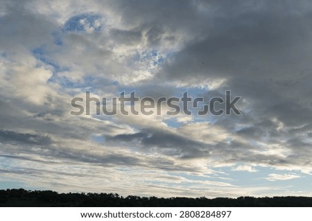 Crepuscular rays piercing clouds above a marsh, Hokkaido, Japan