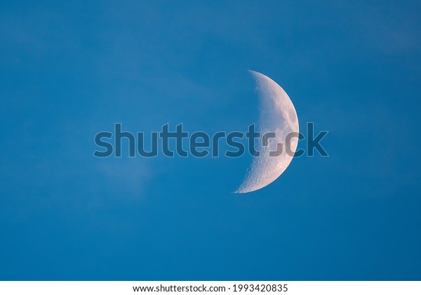 Crescent moon with blue\
sky. Nice young half moon on blue sky.  Selective focus. Copy space\
for any design.