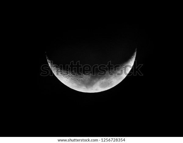 Crescent Moon five day old / The Moon as it appears\
early in its first quarter or late in its last quarter, when only a\
small arc-shaped section of the visible portion is illuminated by\
the Sun