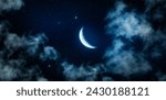 Crescent moon, shining stars and thin clouds in the calm midnight sky. Bottom up view of mysterious night sky view that gives calmness