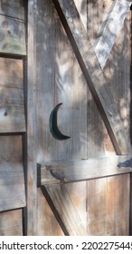 Crescent Moon Symbol On Wooden Outhouse Door.