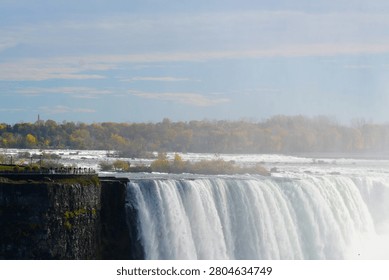 The crest of a massive waterfall drop with thick rising white mist
