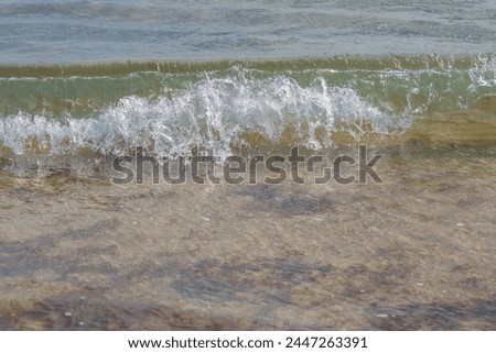 The crest of a wave rolling onto the shore, creating a splash and spray of droplets. Observing Soothing Natural Phenomena.