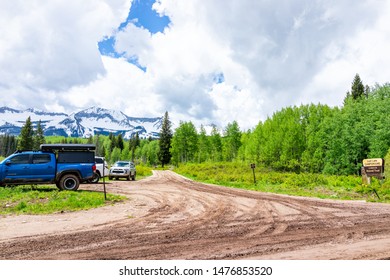 Crested Butte, USA - June 22, 2019: Snow Mountain And Parking Lot At Lost Lake Campground In Summer Aspen Forest And Clouds By Dirt Road In Kebler Pass