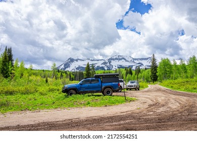 Crested Butte, USA - June 22, 2019: Snow Capped Mountain And Parking Lot At Lost Lake Campground In Summer Aspen Tree Forest With White Clouds By Dirt Road In Kebler Pass