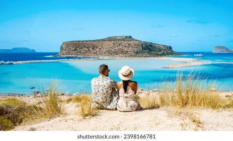 Crete Greece Balos Lagoon Tourists relax at the crystal clear ocean of Balos Beach, a couple of men, and a woman visit the beach during a vacation in Greece