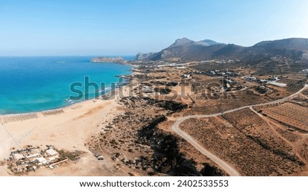 Crete island Greece. Aerial drone panoramic view of Falasarna sandy beach, greenhouse in valley, agriculture area, vast sea water, blue sky.