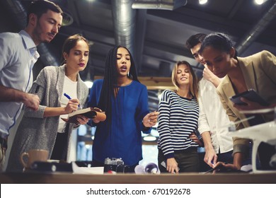 Crew of architect working on creation blueprint for new construction project cooperate with customer telling requires during meeting in coworking office with free wifi zone and digital devices  - Shutterstock ID 670192678