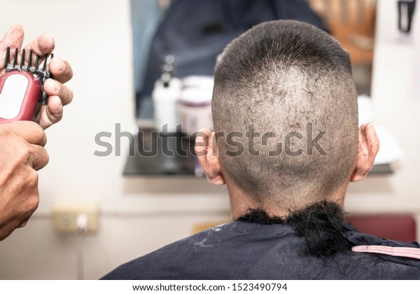 The Crew Cut hairstyle.\
Short and Easy hair for men.\
barber making haircut of man in\
barbershop.