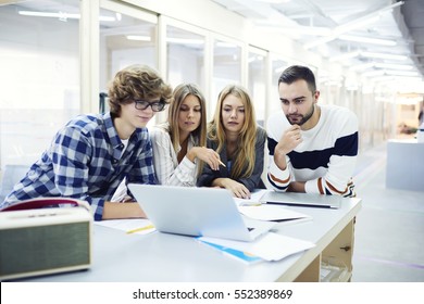 Crew Of International Male And Female Students Watching Streaming Webinar On Business Lesson Preparing For Upcoming University Testing Using Laptop Computer And Wireless Connection In Coworking Place