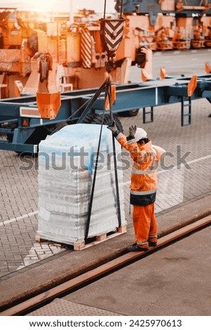 A Crew Member Seafarer Wearing Protective Safety Clothes While Assisting With Delivery Of Ship Supply Spare Parts And Provision Stores. Bonded Goods Order Ready For Transportation On A Wooden Pallet