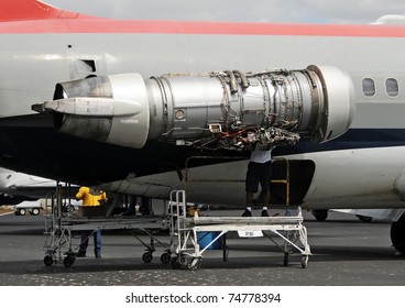 Crew Repairing Jet Airplane Engine Outdoors