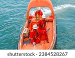 The crew of the ship are working together to steer the lifeboat. maneuvering fast rescue boat to perform evacuation man overboard. rescue man overboard