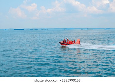 The crew of the ship are working together to steer the lifeboat. maneuvering fast rescue boat to perform evacuation man overboard. rescue man overboard