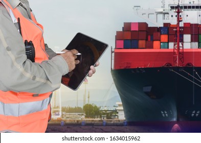 Crew Worker And Hand Holding IPad Or Tablet In Port Cargo Ship Loading Loading Container Box In Harbor, Container Stacking On Ship Background.