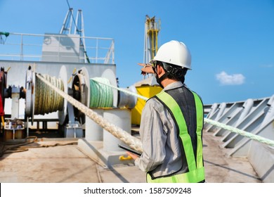 Crew Worker On Ship IPad In Hand Of Engineering Supervisor, Foreman, Inspector Surveyor Tankers Final Operation Control Worker On Ship At Forward On Mooring Winch With Anchor Rope In Drum.