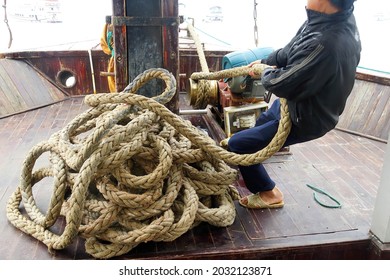 Crewman Hauling In The Anchor On Cruise Ship Junk,  Halong Bay, Vietnam