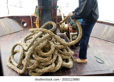 Crewman Hauling In The Anchor On Cruise Ship Junk,  Halong Bay, Vietnam