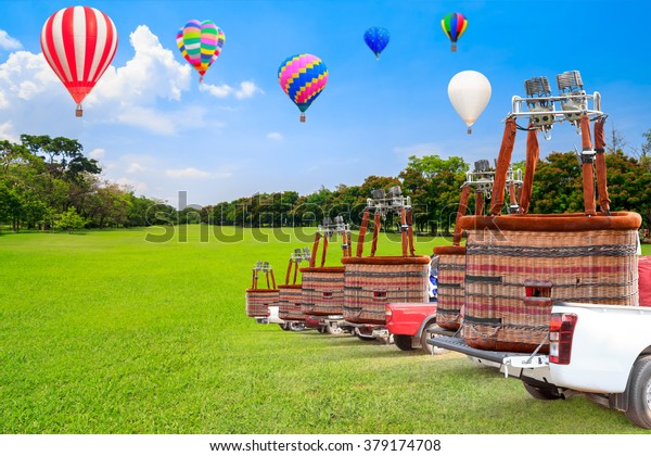The crews\
transportation Hot Air Balloon on car after landing with against\
background balloon flying on blue\
sky