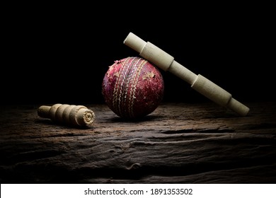 Cricket ball and wickets still life close-up on a highly texture wooden surface. Stock