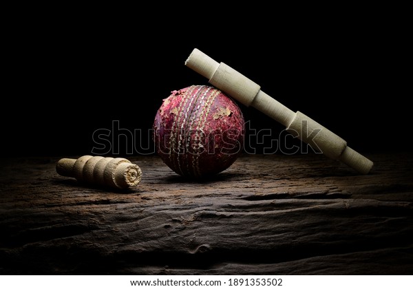 Cricket ball and wickets still life\
close-up on a highly texture wooden surface.\
Stock