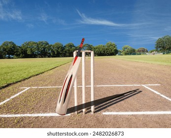 cricket bat and Cricket stumps place on cricket ground .