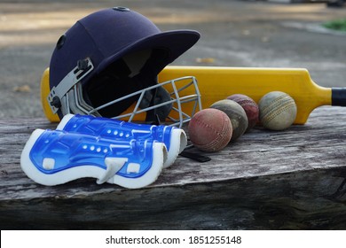 Cricket equipment with helmet, bat, balls and leg protector pads. Concept for outdoor sport. Now Thai students are practicing after school for competition and exercise for heath. - Powered by Shutterstock