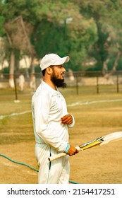 Cricket Player Holding Cricket Bat In Play Ground 