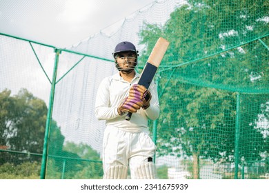 cricket player is ready to practice batting in the nets during his practice time - Powered by Shutterstock