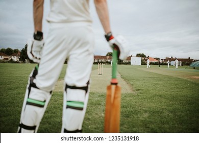 Cricket player standing on a field - Powered by Shutterstock