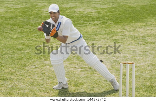 Cricket\
wicketkeeper catching a ball behind\
stumps