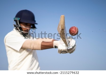 A cricketer playing cricket on the pitch in white dress for test matches. Sportsperson hitting a shot on the cricket ball.