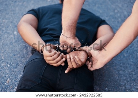 Crime arrest, scam and criminal man with security officer handcuffs on the ground. Back hands of legal justice on a road of a caught guy in the act going to court, jail or prison with police officer