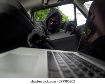 Crime Concept - Thief Stealing Laptop From The Car. View From Laptop