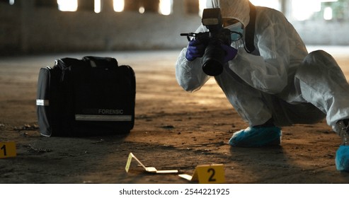 Crime, person and photography at scene for investigation, documentation and evidence in abandoned warehouse. Forensic specialist, PPE or camera in building for legal service, inspection or pathology - Powered by Shutterstock