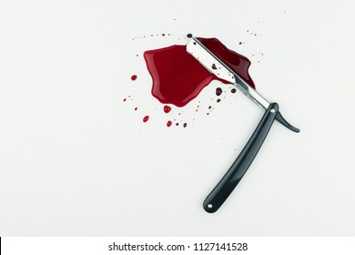 crime scene concept, a bloody vintage straight razor on white background