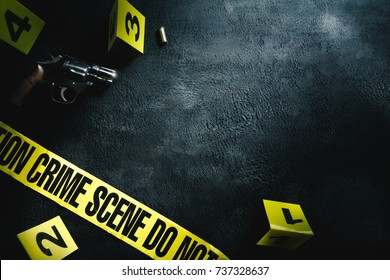 Crime scene concept with a gun and evidence markers / high contrast image